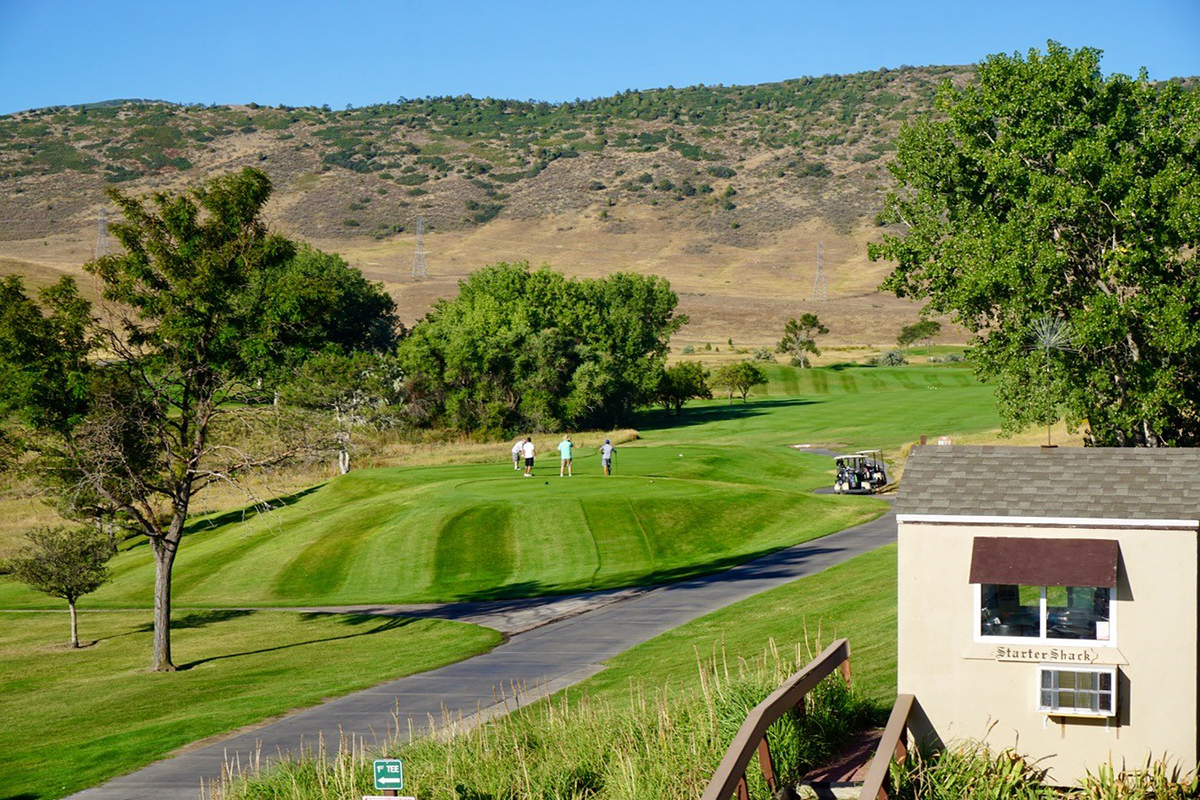 A view of hole number 1 at Meadows Golf Club with a foresome of golfers teeing off on the tee box.